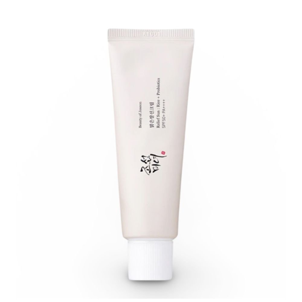Front view of Beauty of Joseon Relief Sun Rice + Probiotics SPF50 PA++++ sunscreen tube (50ml) on white background. Gold Korean text accents the white packaging, with visible labels: "30% Rice Extract," "Probiotics," and "SPF50+ PA++++." A pearl-sized dollop of the creamy, off-white formula is shown blending seamlessly into skin