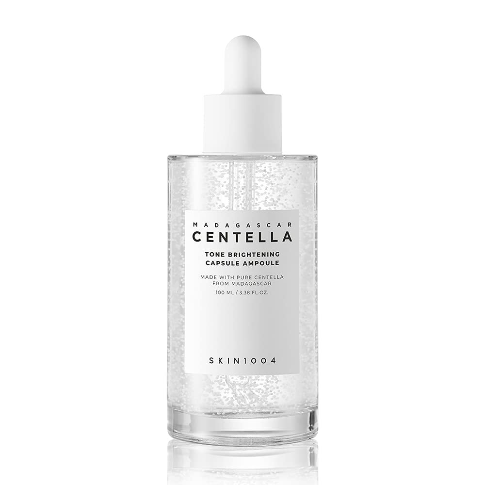 SKIN1004 Madagascar Centella Tone Brightening Capsule Ampoule 50ml—clear bottle with dropper, containing a lightweight, transparent serum with micro-beads, designed to brighten and soothe skin.